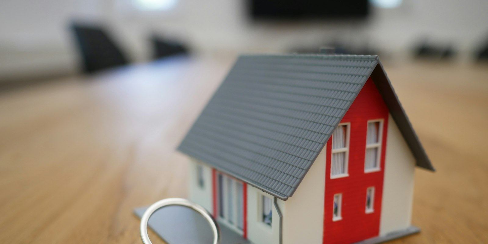 Miniatura de casa com um molho de chaves sobre uma mesa de madeira